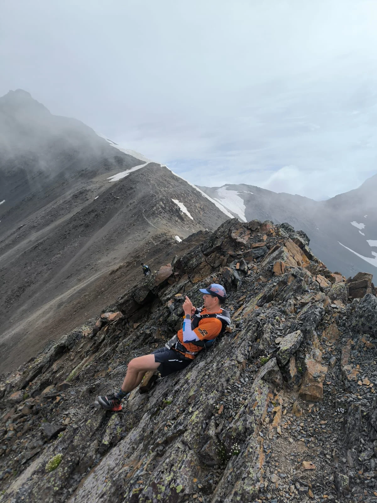 Runner crossing a steep rocky ridge